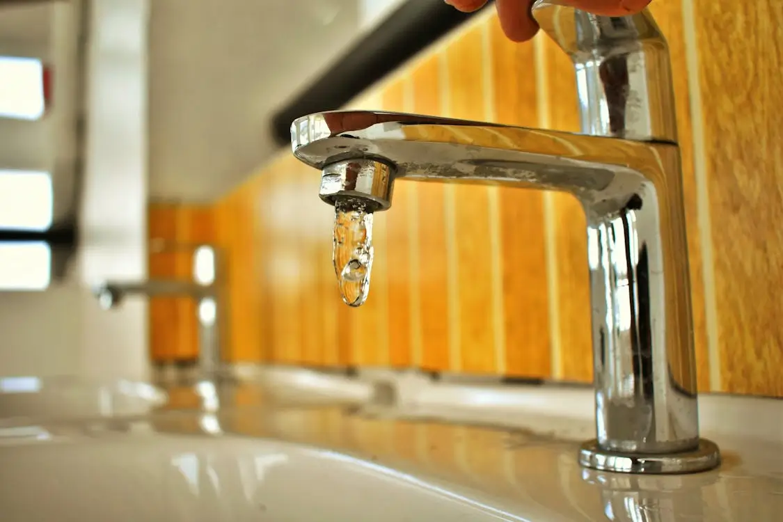 Leaky faucet illustrating clogged drains and plumbing issues.