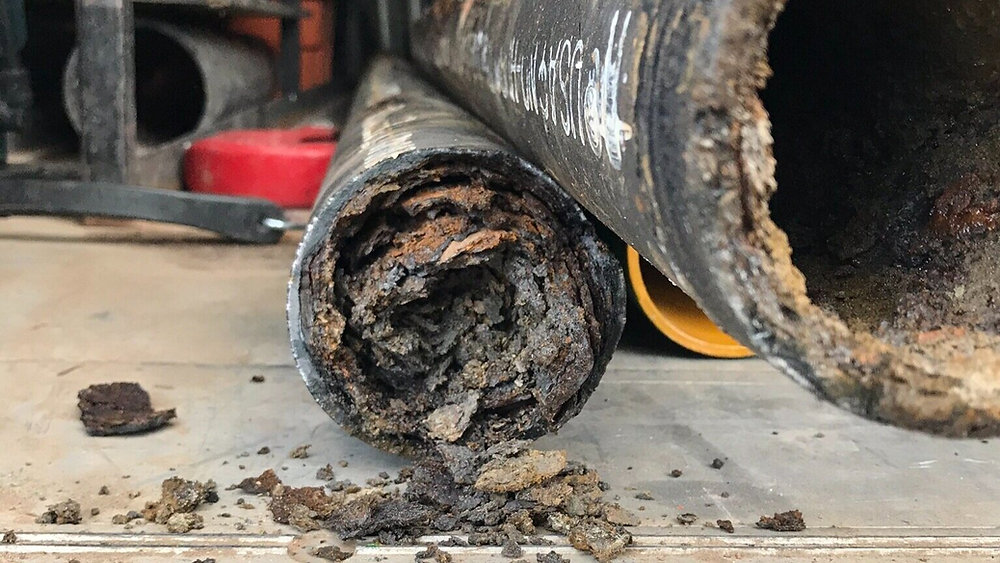 Clogged main sewer line with grease and debris buildup inside pipe