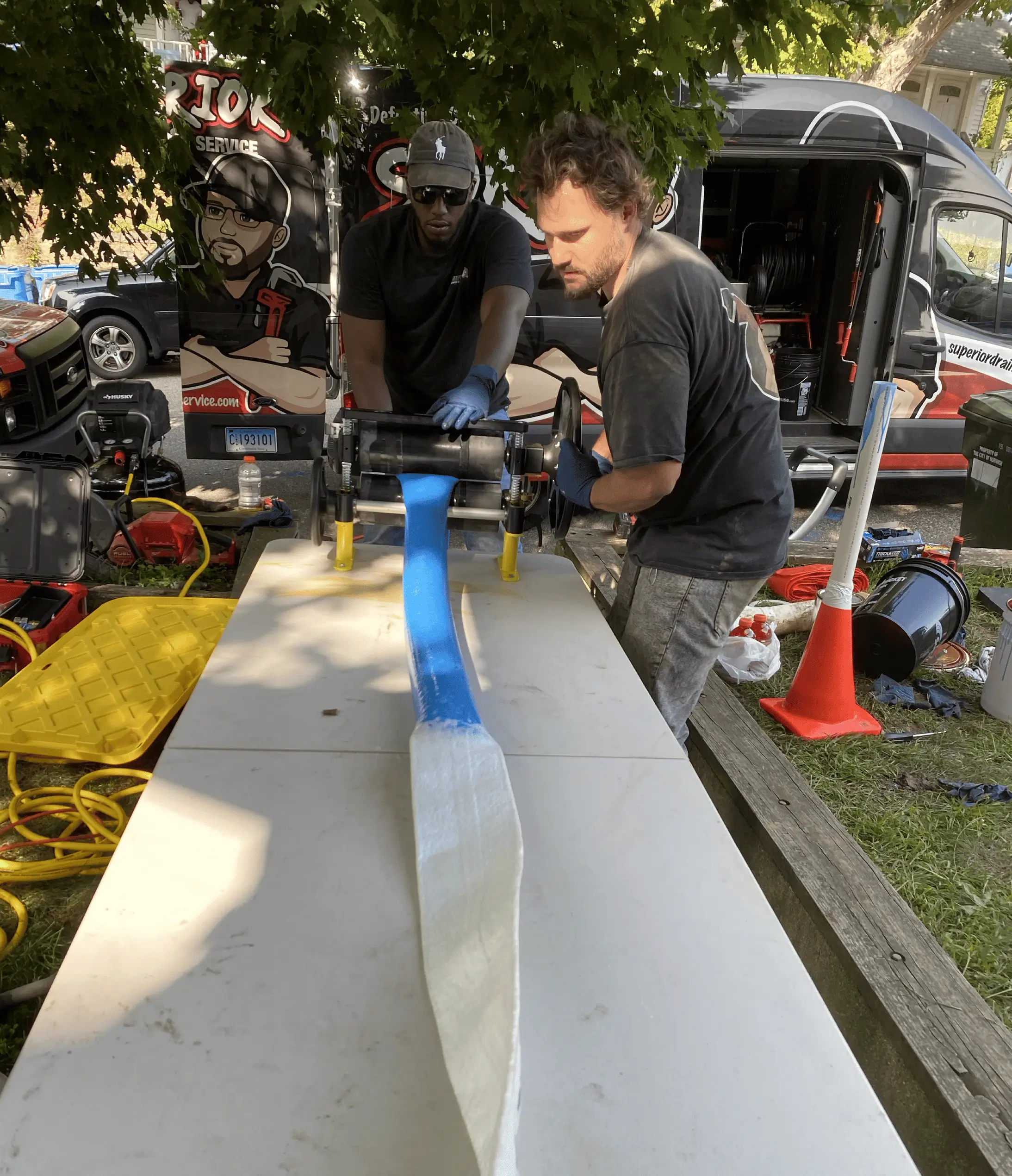 Trenchless pipe lining installation with Superior Sewer & Drain Service technicians and equipment.